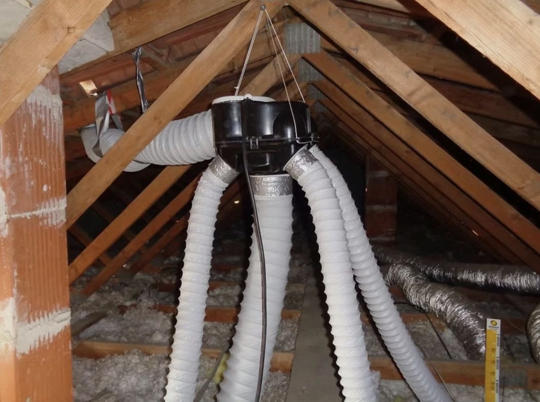 Caisson de VMC et ses gaines de distribution, installé dans des combles